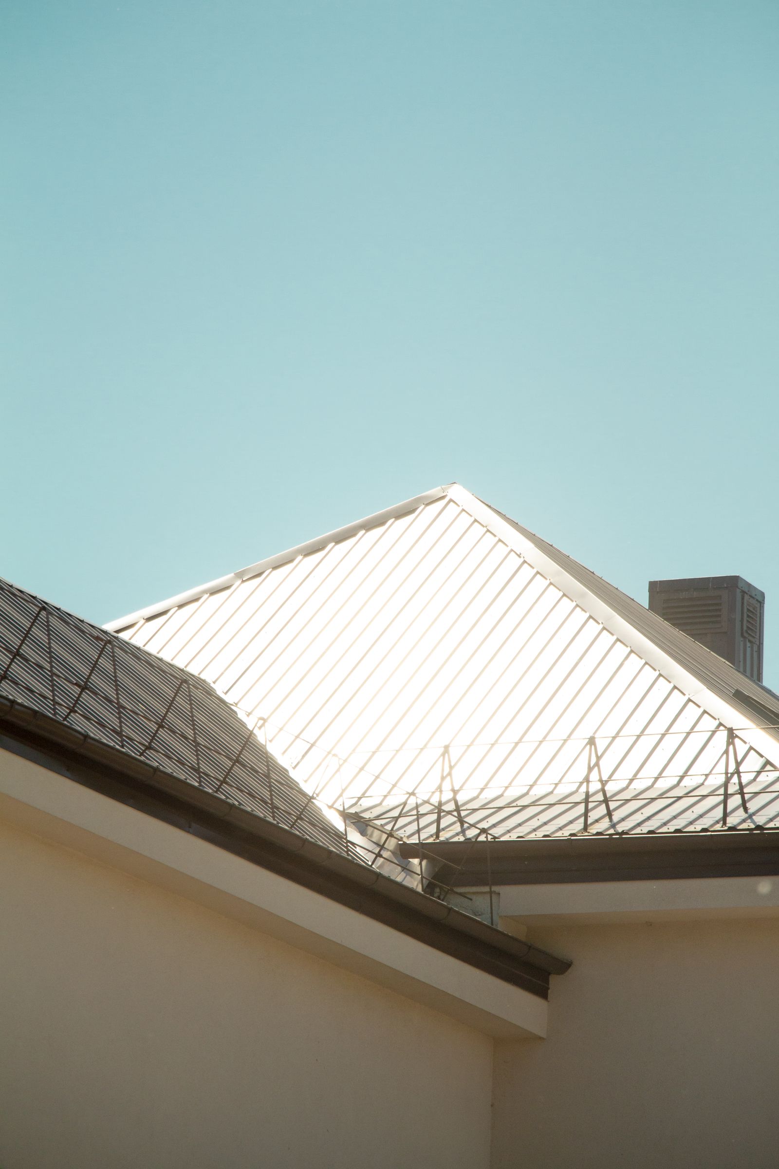 Sunlit standing seam metal roof against the sky